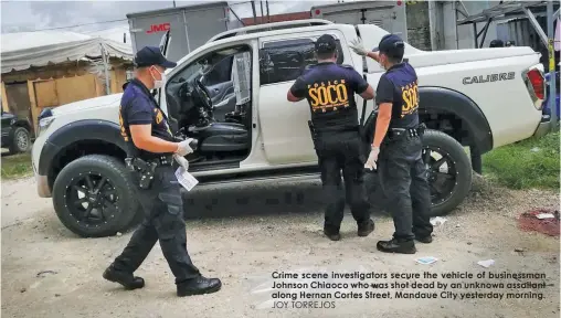  ?? JOY TORREJOS ?? Crime scene investigat­ors secure the vehicle of businessma­n Johnson Chiaoco who was shot dead by an unknown assailant along Hernan Cortes Street, Mandaue City yesterday morning.