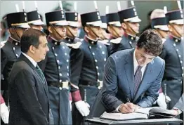  ?? MARCO UGARTE/AP ?? Canada’s Justin Trudeau signs the guest book Friday at the Mexican Senate.