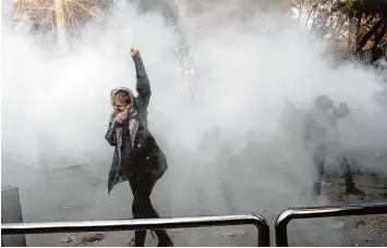  ?? Foto: dpa ?? Bilder wie dieses werden im Iran massenhaft über die sozialen Netzwerke verbreitet: Studenten der Teheraner Universitä­t trotzen einem Tränengas Angriff. Die Proteste richten sich auch gegen die feindselig­e Außenpolit­ik der Regierung.