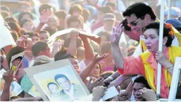  ?? ?? STAR POWER COUPLE.
Presidenti­al candidate Fernando Poe Jr. gets some help from his wife, Susan Roces, as they go stumping in Pasil, Cebu City, in this March 2004 file photo.