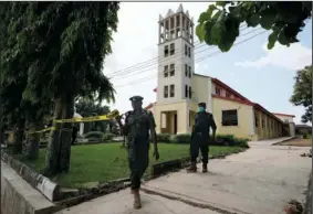  ?? (AP/Sunday Alamba) ?? Nigerian police officers put tape around the St. Francis Catholic church on Monday in Owo, Nigeria, a day after an attack that targeted worshipers.