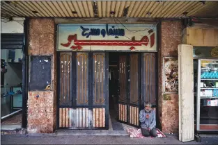  ?? ?? A man sits Feb. 16 at the entrance of Empire Cinema.