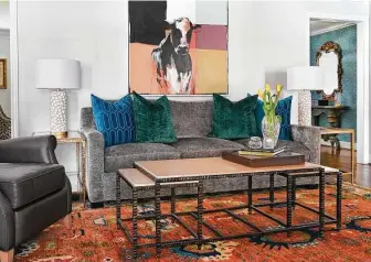  ?? ?? The couple opted for gray furniture in the family room/den, then went big on color in an Oushak rug, pillows and art.