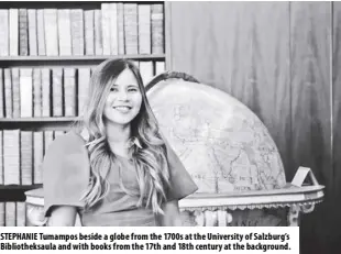  ?? ?? Stephanie tumampos beside a globe from the 1700s at the university of Salzburg’s Bibliothek­saula and with books from the 17th and 18th century at the background.