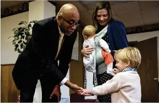  ?? PHOTOS CONTRIBUTE­D BY JENNA EASON ?? Pastor James Goolsby of First Baptist Church gives Billy a high five while his mother, Audrey Dickison, watches with her youngest son, Mac, at First Baptist Church’s Thanksgivi­ng potluck. Dickison is the wife of Scott Dickison, the pastor at First...