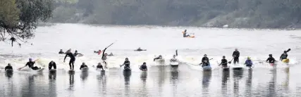  ?? PAUL NICHOLLS ?? Surfers and canoes ride the four-star Severn bore on the River Severn in Gloucester­shire yesterday