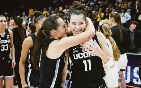  ?? Craig Mitchelldy­er / Associated Press ?? UConn’s Lou Lopez Sénéchal (11) and Nika Muhl celebrate winning the Phil Knight Legacy championsh­ip over Iowa 86-79 on Sunday.