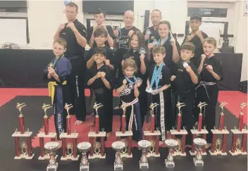  ??  ?? Hicks Karate School of Excellence with their medals and trophies from the Peterborou­gh Championsh­ip Series