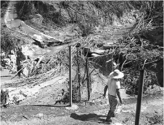  ??  ?? Motorists stop to collect water at a natural spring that has been tapped with makeshift pipes.