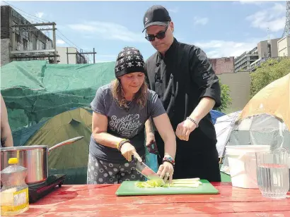  ?? RANDY SHORE/PNG FILES ?? Drew Borus of the Potluck Cafe Society teaches volunteer Samona Marsh sanitation and basic cooking skills at the tent city protest camp on West Hastings Street.