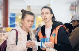  ?? CHISATO TANAKA/AP ?? Elena Trofimchuk, right, who fled Ukraine to Romania more than a month ago, helps a refugee sort out train tickets April 23 at the North Railway Station in Bucharest.