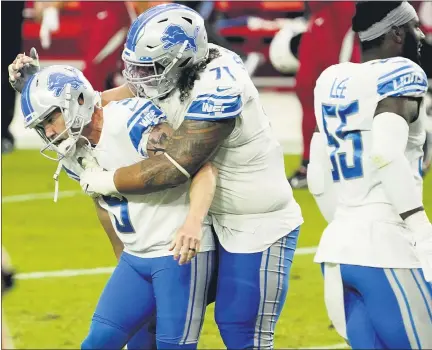  ?? RICK SCUTERI — THE ASSOCIATED PRESS ?? Detroit Lions’ Danny Shelton, center, embraces teammate Matt Prater, left, after Prater kicked the game-winning field goal as time expired against the Arizona Cardinals on Sunday. The Lions edged the Cardinals, 26-23, to end an 11-game losing streak going back to last season.