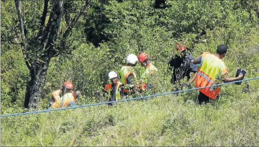  ?? Pictures: CHUMA NOBANDA / SIKHO NTSHOBANE ?? RESCUE MISSION: Rescue teams at the site where a man went over a 100m cliff and was trapped for more than 19 hours in his mangled car in Ngqeleni. The body was retrieved around midday yesterday after rescuers used the jaws of life to cut it free. Top...