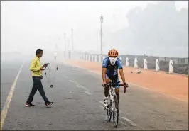  ?? MANISH SWARUP / ASSOCIATED PRESS ?? A cyclist pedals through the morning smog in New Delhi on Friday. Environmen­tal pollution — from filthy air to contaminat­ed water — is killing more people every year than all the war and violence in the world.