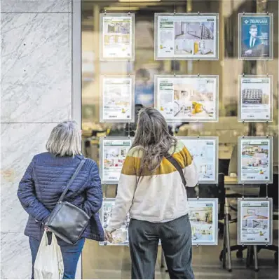  ?? Manu Mitru ?? Dos mujeres observan los anuncios de una agencia inmobiliar­ia en Barcelona.