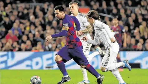  ?? Emilio Morenatti / Associated Press ?? El argentino Lionel Messi (izq.) escapa de la marca del croata Luka Modric durante el empate sin goles en el clásico entre el local Barcelona y el Real Madrid en el estadio Camp Nou, el miércoles 18 de diciembre.