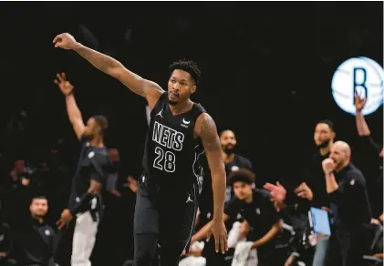  ?? ADAM HUNGER/AP ?? Brooklyn Nets forward Dorian Finney-Smith, a former Norcom High star shown reacting to a 3-pointer on Dec. 8, has reunited with his father, Elbert Smith, who was granted parole after being incarcerat­ed for nearly 29 years.