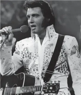  ?? AP ?? Elvis Presley, shown in an undated file photo, wears one of his white jumpsuits during a concert in the later part of his career.