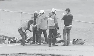  ??  ?? Rescue personnel gather at a staging area in Lions Bay on Sunday after five hikers fell about 500 metres on nearby Mount Harvey. All five were found dead on Sunday.