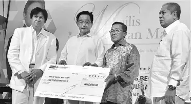  ??  ?? Abdul Karim (second left) witnesses the presentati­on of a mock cheque for the donations by Abang Khalid (left) to a recipient.