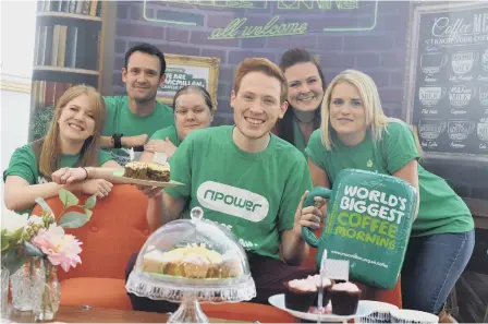  ??  ?? Bake Off star Andrew Smyth, also left, helps out at npower’s Macmillan’s coffee morning.
