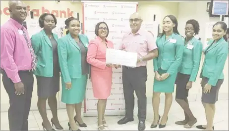  ??  ?? Products and Marketing Manager for Scotiabank Jennifer Cipriani hands over a symbolic cheque to Club Captain Brian Glasford