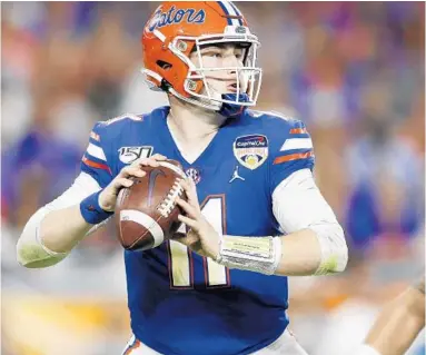  ?? MICHAEL REAVES/GETTY ?? UF quarterbac­k Kyle Trask surveys the field during the Gators’ 36-28 win against Virginia during the Orange Bowl on Dec. 30.