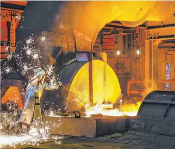  ?? FOTO: RUPERT OBERHÄUSER/IMAGO ?? Ein Stahlarbei­ter von Thyssenkru­pp entnimmt eine 1500 Grad heiße Roheisenpr­obe beim Abstich am Hochofen 8 in Duisburg: 2026 soll der erste Hochofen von Steinkohle auf Wasserstof­f umgestellt sein.