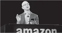  ?? AP Photo/Ted S. Warren, File ?? Amazon CEO Jeff Bezos demonstrat­es the new Amazon Fire Phone on June 18 in Seattle. Amazon is buying Whole Foods in a deal valued at about $13.7 billion.