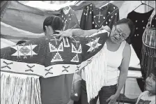  ?? Courtesy photo ?? An Arapaho mother dresses her daughter. Representa­tives of the Northern and Southern Arapaho tribes visited Boulder in 2018 and 2019 for Indigenous Peoples Day. This year Indigenous Peoples Day events include an online webinar and dialogue between Boulder officials and Arapaho leaders.