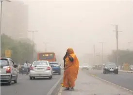  ??  ?? A woman walks with her face covered during a dust storm in New Delhi on May 2, 2018.