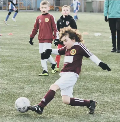  ??  ?? Newton Aycliffe Juniors Whites Under-7s (burgundy) taking on Shildon AFC Youth (black).