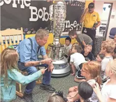  ?? CLARK WADE, THE INDIANAPOL­IS STAR ?? Three-time Indy 500 winner Bobby Unser and the Borg-Warner trophy visited West Clay Elementary School on May 17.