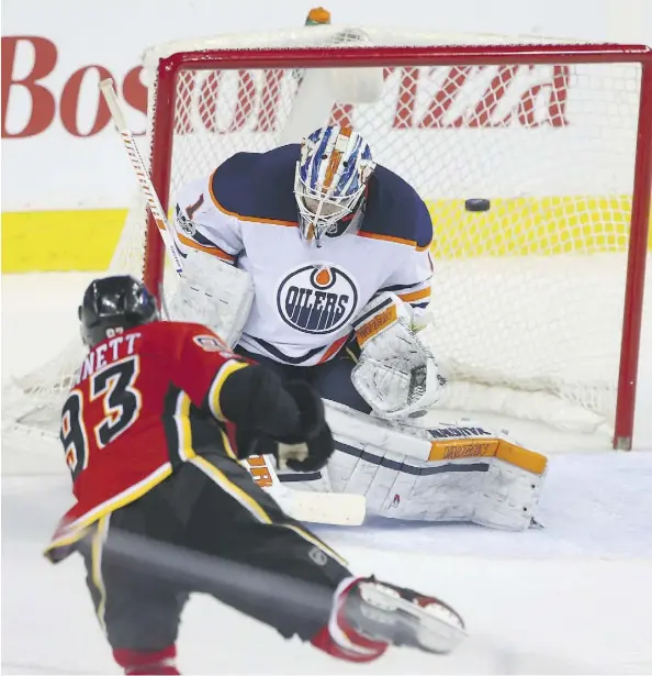  ?? JIM WELLS ?? Calgary Flames winger Sam Bennett scores his second of the game against the Oilers’ Laurent Brossoit Saturday at the Scotiabank Saddledome in Calgary. The Oilers were 7-5 winners, but nearly blew a five-goal lead in the third period.