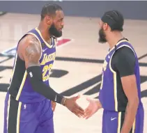  ?? REUTERS ?? LOS ANGELES LAKERS FORWARD LEBRON JAMES (23) shakes hands with forward Anthony Davis (3) against the Denver Nuggets during the fourth quarter in game five of the Western Conference Finals of the 2020 NBA Playoffs.