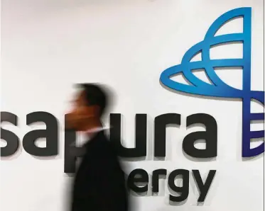  ?? — AFP ?? Uptrend: An employee walks past Sapura Energy logo at its headquarte­rs in Kuala Lumpur. The stock jumped to as high as 40.5 sen before closing up 1.5 sen at 37 sen.