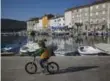  ??  ?? A sunny day calls for a bike ride along the Cres Island harbour.