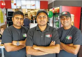  ?? STAFF FILE PHOTO | STAFF PHOTO BY C.B. SCHMELTER ?? Top: Charles Amin, Bob Bhagat and Roshan Amin, from left, participat­e in the grand opening of Holiday Inn & Suites. Above: Franchise partners Pratik Patel, left, P.J. Patel and Nick Patel pose at Paisano’s Pizza.