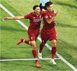  ??  ?? Liverpool FC players celebrate a goal against Paris Saint-germain during their Champions League match in Liverpool, England