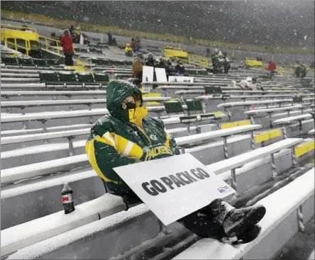  ?? MIKE ROEMER ?? FILE - A few fans watch in Lambeau Field during the first half of an NFL football game between the Green Bay Packers and the Tennessee Titans in Green Bay, Wis., in this Sunday, Dec. 27, 2020, file photo. The eight teams hosting NFL playoff games this month are more than happy to be staying home with all of comfort it brings, but the actual advantage of playing there all but disappeare­d during this pandemic season of mostly empty stadiums.