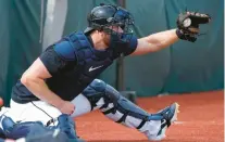  ?? CHARLIE NEIBERGALL/AP ?? Tigers catcher Carson Kelly catches a pitch in the bullpen during a spring training workout Friday in Lakeland, Florida.