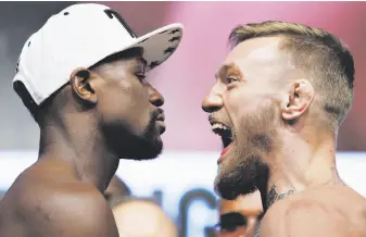  ?? John Locher / Associated Press ?? Floyd Mayweather, left, and Conor McGregor face off during weigh-ins Friday.