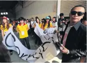  ??  ?? LOST FOR WORDS: A plaincloth­es police
officer, right, tells Thammasat students to surrender a banner deemed to contain ‘inappropri­ate’
words.