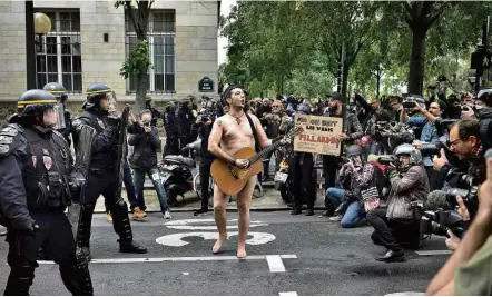  ?? Christophe Archambaul­t/AFP ?? NU COM CAUSA Manifestan­te toca violão em frente a policiais, em Paris, em protesto contra a reforma trabalhist­a do governo de Emmanuel Macron; sindicatos franceses organizara­m atos em diversas cidades do país ontem