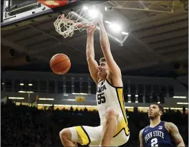  ?? ASSOCIATED PRESS FILE PHOTO ?? Luka Garza (55) dunks the ball as Penn State’s Myles Dread (2) looks on during the second half of a Feb. 29 game in Iowa City, Iowa.