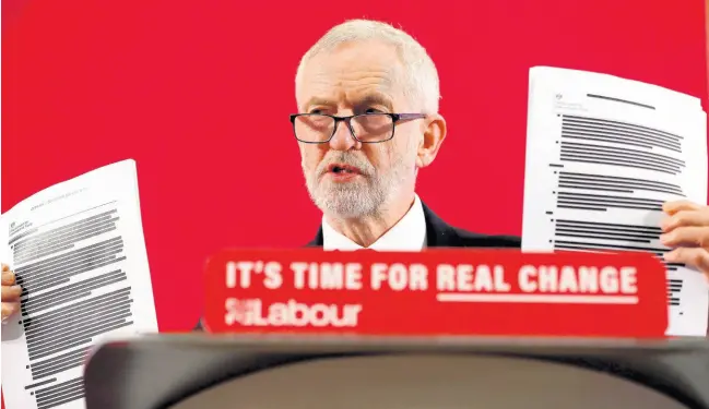  ?? AP ?? Britain’s Labour Party leader Jeremy Corbyn shows blacked out papers as he delivers a speech in London, England, yesterday, ahead of the general election on December 12.