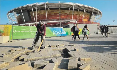  ?? Návštěvníc­i olympijské­ho parku v Riu ještě několik dnů před zahájením her zhusta míjeli dělníky, kteří dokončují některé stavby. FOTO PROFIMEDIA ?? V plné práci.