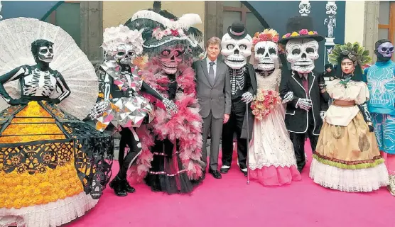  ?? LETICIA SÁNCHEZ ?? El secretario de Turismo, Enrique de la Madrid, posa al lado de las tradiciona­les catrinas y calaveras.