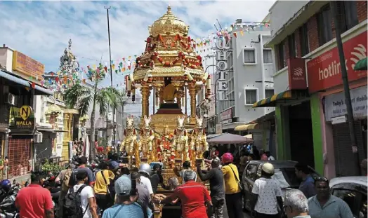  ?? — ZHAFARAN NASIB and CHAN BOON Kai/The Star ?? Devotion: Volunteers hauling the golden chariot towards the Sri Maha Mariamman temple in Queen Street, George town, Penang. (below) Nattukotai Chettiar temple workers decorating the silver chariot which will carry Lord Murugan.