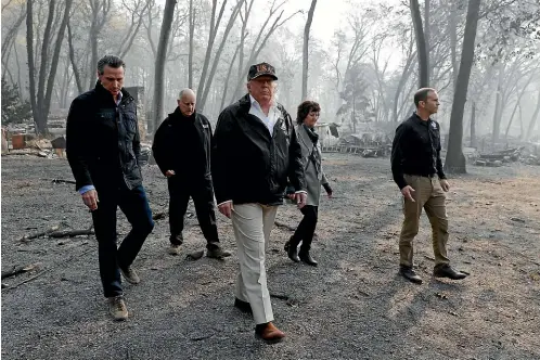  ?? AP ?? President Donald Trump, front, tours Paradise, California, with, from left, Governor-elect Gavin Newsom, California Governor Jerry Brown, Paradise Mayor Jody Jones and FEMA Administra­tor Brock Long during a visit to a neighbourh­ood burnt out by the wildfires.